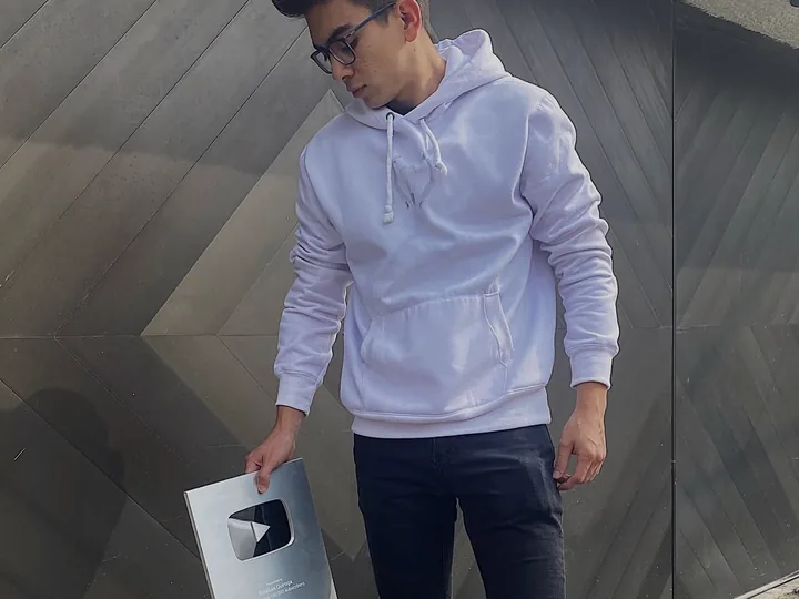 Esteban sosteniendo su placa de YouTube por superar 100.000 suscriptores